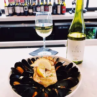 a plate of mussels and a glass of wine