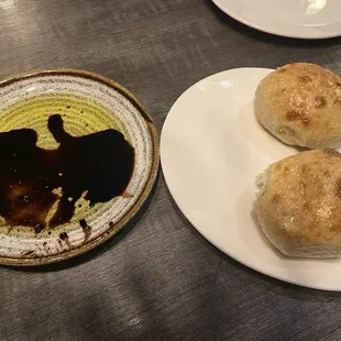 a plate of buns and a bowl of sauce
