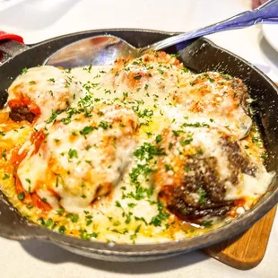 a skillet with meatballs and cheese