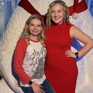two women in front of a polar bear