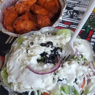 a plate of chicken wings and salad