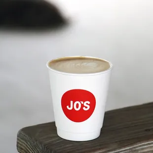 a cup of coffee on a bench