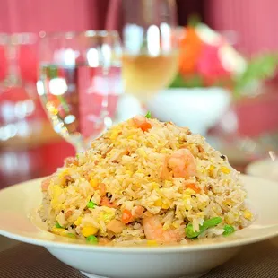 a plate of fried rice with carrots and peas