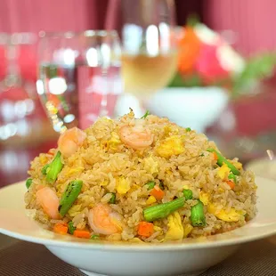a plate of fried rice with shrimp and vegetables
