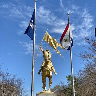 Flags in the sky at the Joan of Arc statue near the French Market of New Orleans