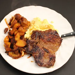 a plate of steak, potatoes, and eggs