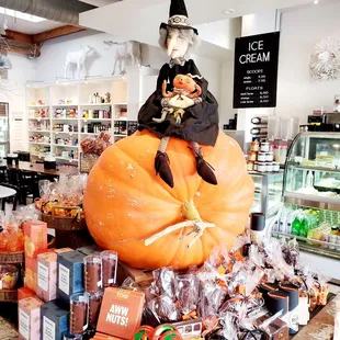 a little witch sitting on a pumpkin