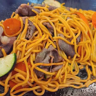 a stir fry of noodles with meat and vegetables