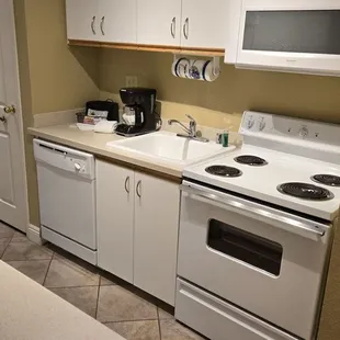 Small kitchen that is oldest appliances and cabinets you&apos;ve ever seen in any condo resort