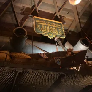 a wooden boat with a sign hanging from the ceiling