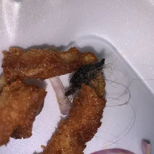 fried chicken strips in a styrofoam container