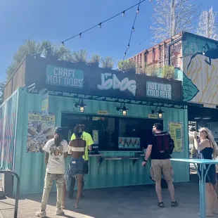a group of people standing in front of a food stand