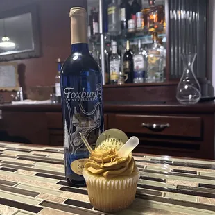 a bottle of wine and a cupcake
