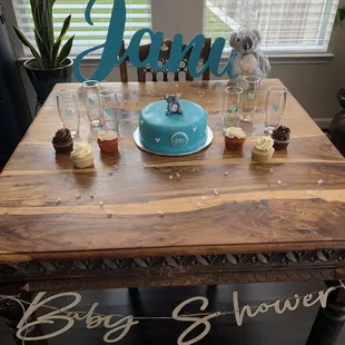 a table with a cake and cupcakes