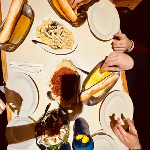 a group of people sitting at a table with plates of food