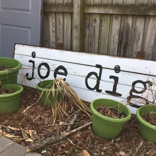 three planters in front of a sign