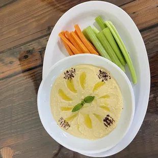 a bowl of hummus and carrots