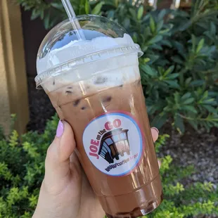 a hand holding a cup of iced coffee