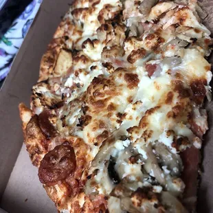 Pizza with chicken, pepperoni, feta, and mushrooms.