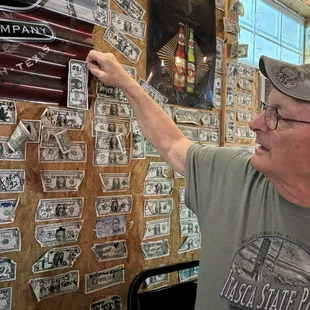 Hanging our We were here dollar bill on the wall.
