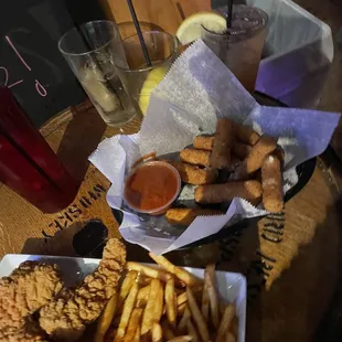 a plate of fried chicken, fries, and dipping sauce