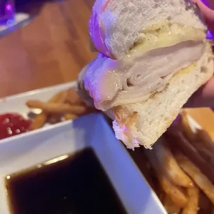 a hand holding a half eaten sandwich