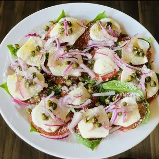 Caprice salad. Fresh basil, Roma tomatoes, Buffalo mozzarella, capers and onions, with a delicious vinaigrette dressing!