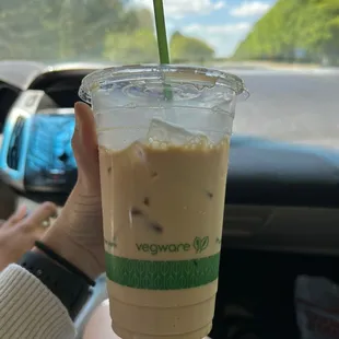 a hand holding a cup of iced coffee