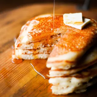 a stack of pancakes with butter and syrup