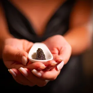 a woman holding a small bowl of cavia