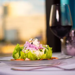 a plate of salad and a glass of wine
