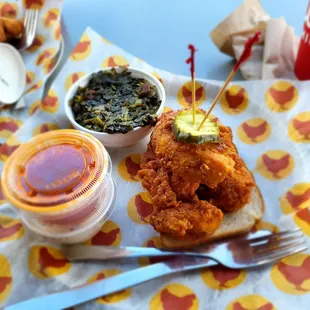a fried chicken sandwich with a side of greens