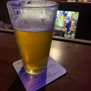 a glass of beer on a coaster
