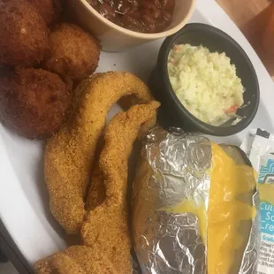 Catfish filets, hush puppies, baked beans, slaw, and baked potato
