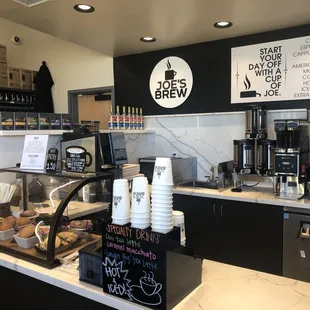 a coffee shop counter with a variety of coffees