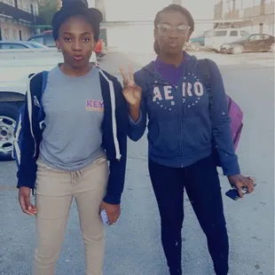 two girls standing in a parking lot