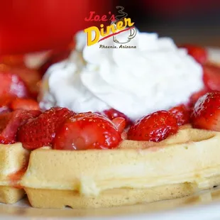 a waffle with strawberries and whipped cream