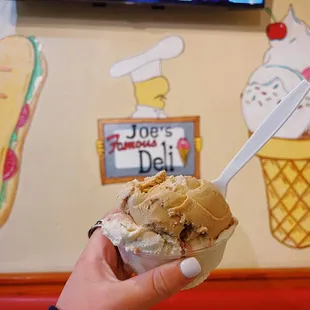 a hand holding a scoop of ice cream