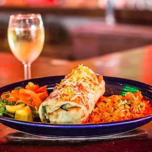 Vegetarian Burrito with a glass of chardonnay. Fresh steamed veggies and rice
