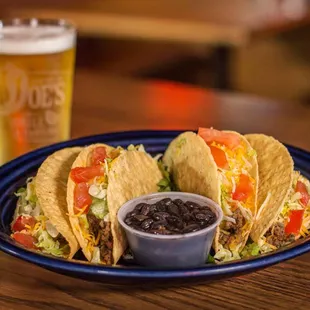 a plate of tacos and a pint of beer