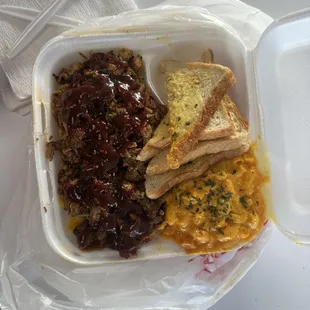 pulled pork over rice with garlic bread and mac and cheese