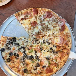 One slice missing of our small half/half pizza