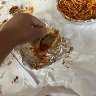 a hand grabbing a piece of pizza