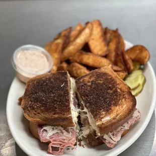 grilled reuben with a side of seasoned wedges