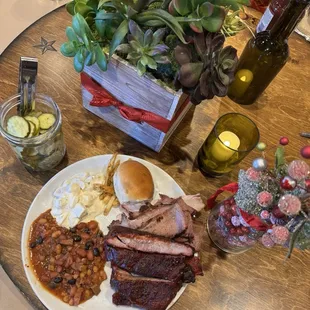 Sliced beef brisket, ribs, BBQ beans, and potato salad.