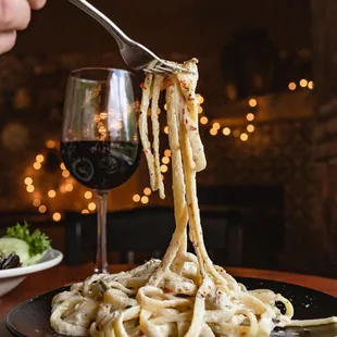 a plate of pasta being eaten with a fork