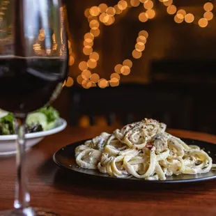 a plate of pasta and a glass of wine