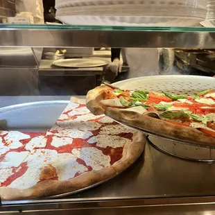 two pizzas on a counter