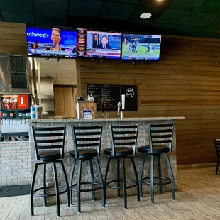 a bar with four televisions on the wall