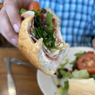 a person holding a sandwich